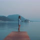 Young woman standing at the edge of a dock contemplating the sunrise - VideoHive Item for Sale