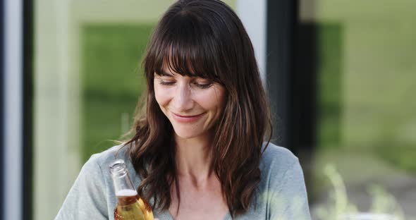 Happy woman toasting with a bottle of beer