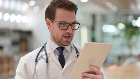 Portrait of Male Doctor Talking on Video Chat on Tablet