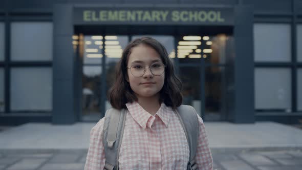 Serious School Girl Standing on Schoolyard Closeup