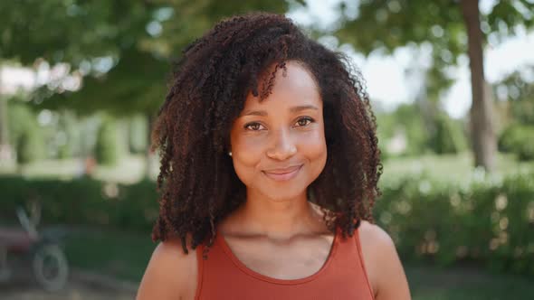 Pretty African woman looking at the camera and posing in the park