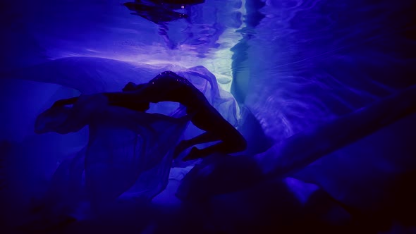 Enigmatic and Fantastic Underwater Shot Female Silhouette in Dark and Enigmatic Depth of Pool