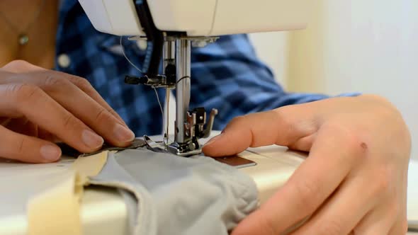 Young Woman Sews Underwear on a Sewing Machine