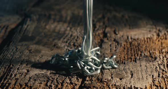 Iron Chain Falling Down Into an Aged Wooden Floor