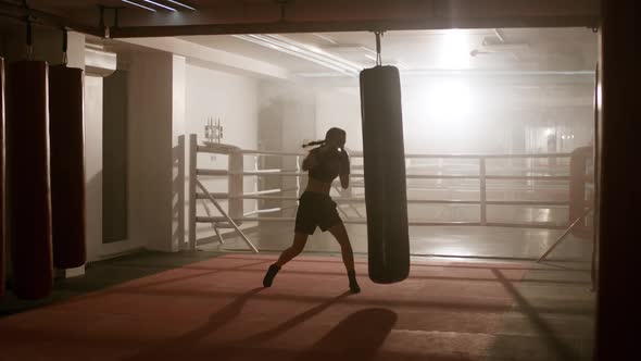 Female Fighter Trains His Punches, Beats a Punching Bag, Training Day in the Boxing Gym