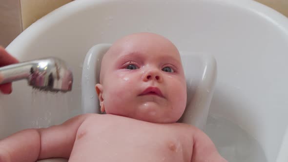 Mother Bathes a Small Child in a Bath