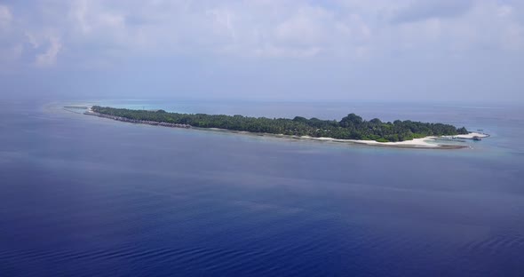 Tropical overhead tourism shot of a white sand paradise beach and blue ocean background in colorful 