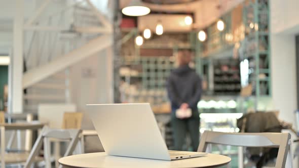 Laptop Open on Table in Empty Cafe