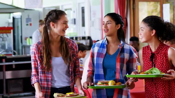 Schoolgirls interacting with each other while having meal 4k