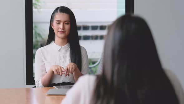 Beautiful woman work together with concept of social distance by sit on different side