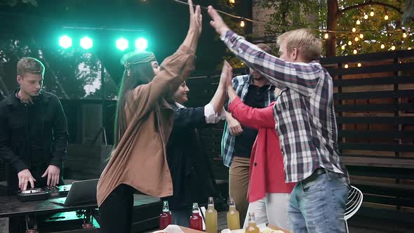 Beautiful Cheerful Young People Giving High Five Each Other and Having Fun Together