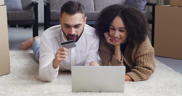 Multiethnic Couple Caucasian Man and African American Woman Husband and Wife Lying on Floor Looking