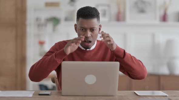 African Man Reacting to Loss While using Laptop