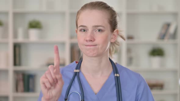 Serious Young Female Doctor Saying No By Finger Sign