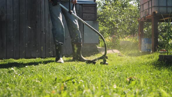 Male Gardener Mowing Green Lawn with Manual Gas Grass Mower Garden Maintenance