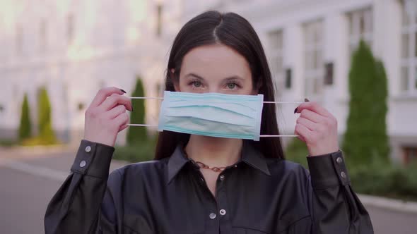 Woman Puts on a Protective Mask.