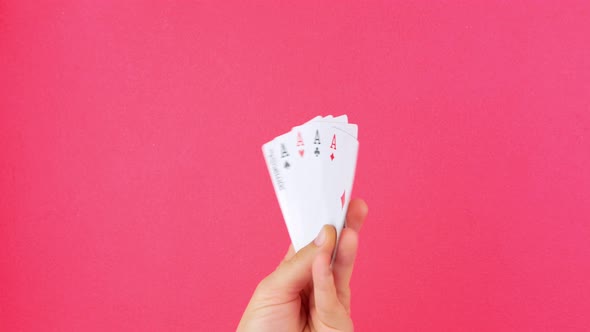 Five of kind Poker Game cards in gambler hand falling money bills pink background Lucky combination