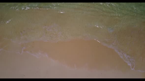 Aerial flying over sky of tropical resort beach break by aqua blue water with white sand background 