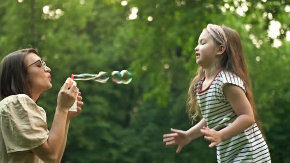 Young Woman Blows Soap Bubbles