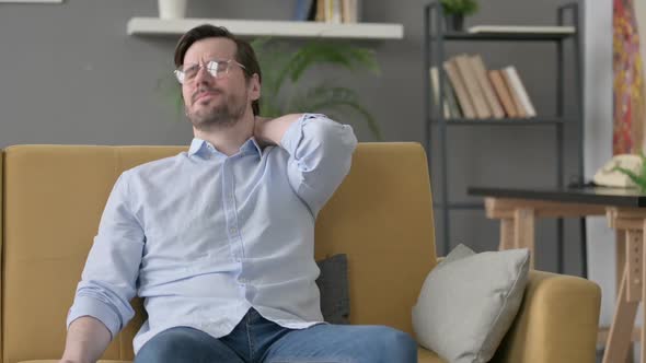 Young Man Having Neck Pain While Sitting on Sofa