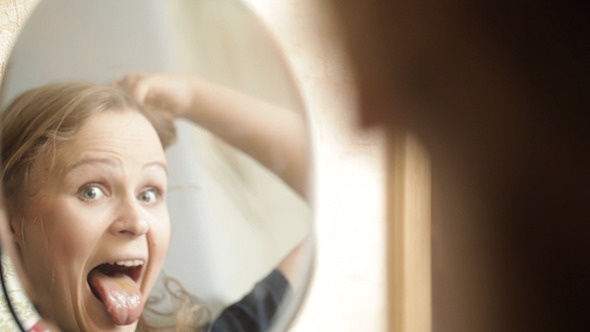 Girl Grimaces In The Mirror