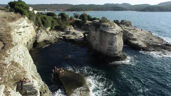 Rocks in The Sea And People Standing On It 