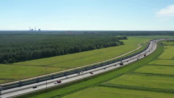 Asphalt Speedway with Cars Through Green Field. Aerial View From Drone