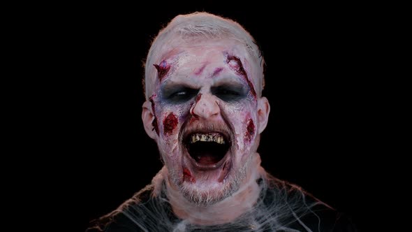 Sinister Man Halloween Crazy Zombie with Bloody Wounded Scars Face Trying to Scare on Black Room