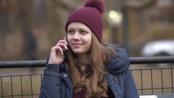 Taking a Phone Call While Sitting on a Bench at Central Park New York