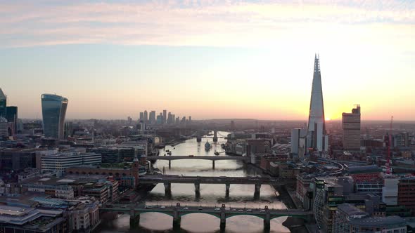 Cinematic dolly forward aerial drone shot of sunrise over Thames river and central London