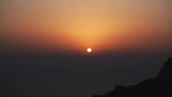 sunset timelapse over dingli cliffs in malta europe showing orange sun with soft color gradations