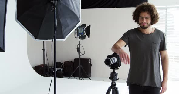 Photographer standing with digital camera in studio