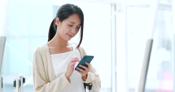 Woman holding smart phone in the airport