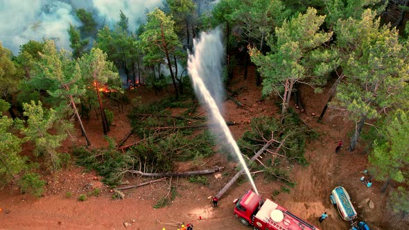 Firefighters Spray Water To Wildfire