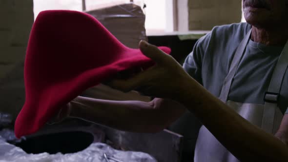 Mixed race man working at a hat factory