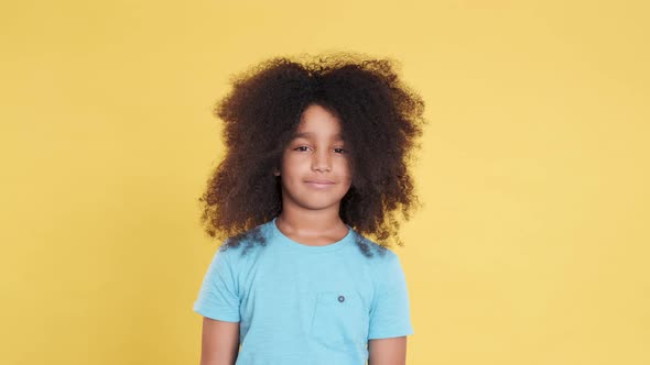 Portrait of Pensive or Ambiguous Little Girl with Lush Curly Hairstyle