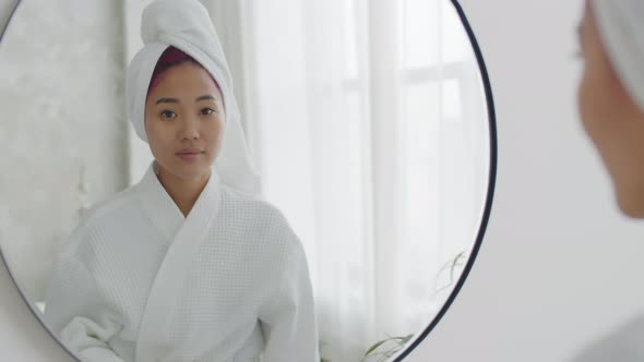 Asian Woman in Bathrobe and Towel on Head Posing for Camera