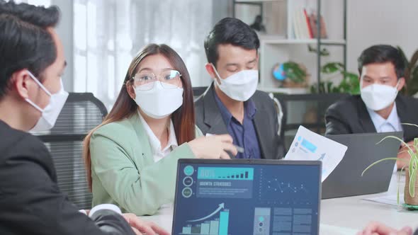 Asian Team Wear Face Mask Have Meeting In A Conference Room. They Share Opinions, Statistics ON TV