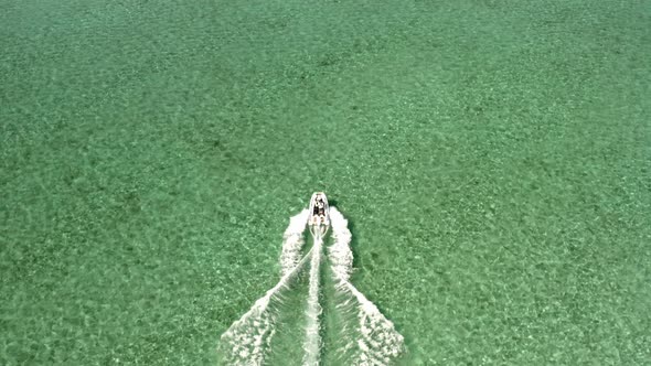 Motorboat Sailing in Turquoise Tropical Sea Water Birdseye Tracking Drone Aerial View