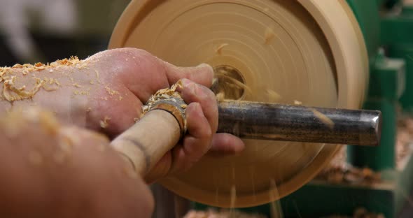 Closeup of carpenter turning wood on a lathe