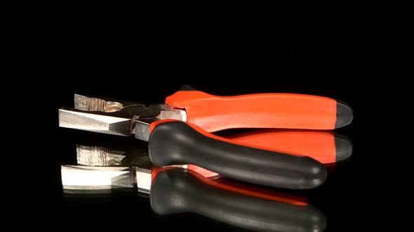 Gray and Red Pliers on Black, Reflection, Rotation