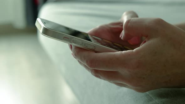 phone is in women's hands, the girl uses the smartphones typing on the screen