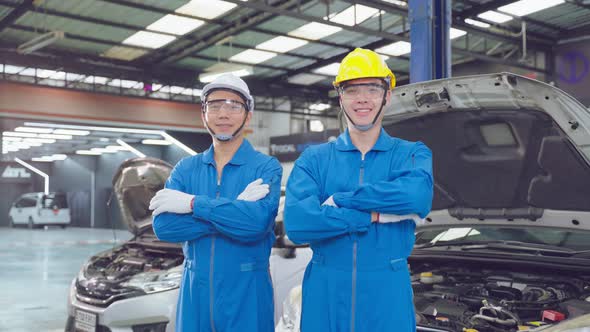 Portrait of Asian two handsome automotive mechanic men stand in garage.