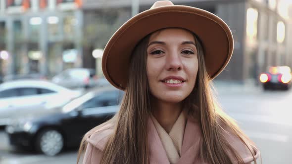 Close up portrait of Charming long hair young woman in a coat and round hat