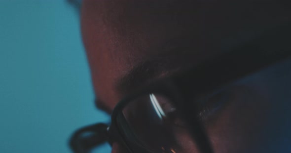 A young man with glasses looks down