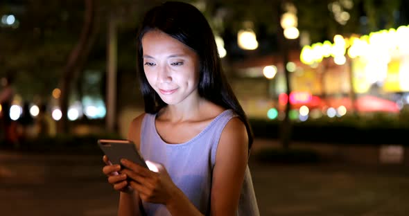 Young Woman Working on Cellphone at Night 