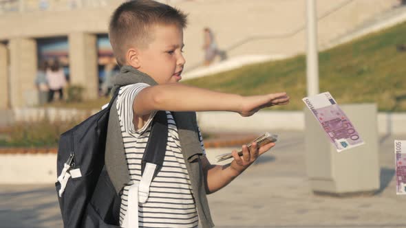 Little Boy Standing and Throwing Euros in the Air.