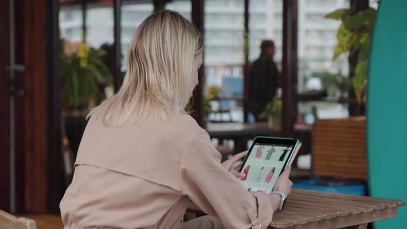 Female Visitor of Cafe Is Sitting Outdoor and Shopping Online By Tablet