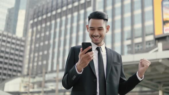 Successful Asian businessman winner celebrates the good news.