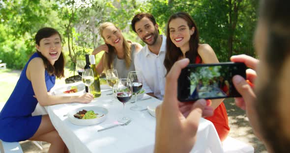 Man taking picture of his friends with mobile phone